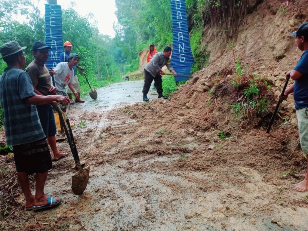 Bhabinkamtibmas Polres Tator Bersama Warga Bersihkan Material Tanah Longsor di Lembang Salu