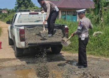 Personel Satlantas Polres Luwu Timur Perbaiki Jalan Rusak dan Berlubang di Desa Ussu