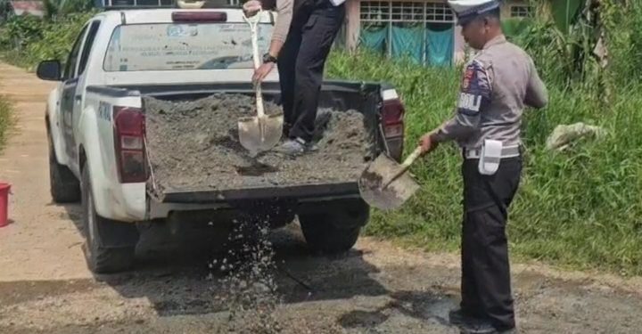Personel Satlantas Polres Luwu Timur Perbaiki Jalan Rusak dan Berlubang di Desa Ussu