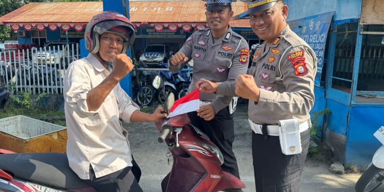 Semarak HUT RI ke-80, Kasat Lantas Polres Palopo Bagi Bendera Merah Putih ke Pengendara