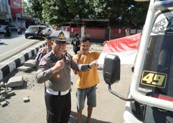 Satlantas Polres Gowa Bagi Bendera Merah Putih dan Bunga kepada Pengendara