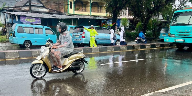 Dibawah Guyuran Hujan, Personel Polsek Turikale Tetap Atur Arus Lalu Lintas