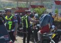 Personel Sat Lantas Polres Palopo Bagi Air Mineral ke Masyarakat Yang Antri BBM