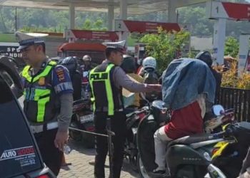 Personel Sat Lantas Polres Palopo Bagi Air Mineral ke Masyarakat Yang Antri BBM